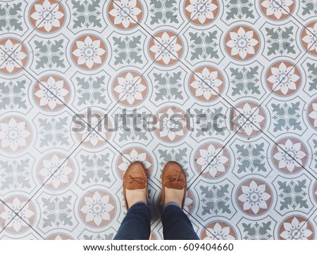 Top view selfie of feet in leather shoes on the vintage seamless floor background with copy space