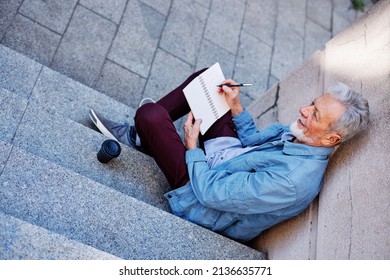 Top View Of A Senior Man Sitting Outside And Writing To Do List.