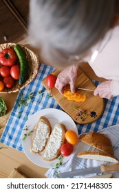 Top View Of Senior Woman Preparing Healthy Sandwich With Fresh Farm Vegetables