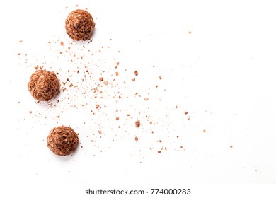 Top view of set of beautiful and delicious chocolate truffle sweets decorated with assorted wafer crumbs isolated on a white background. Closeup studio shot with soft selective focus.