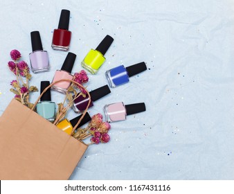top view the set for manicure   pedicure  bright gel varnishes   flowers poured from the kraft package background and space for text Nail work flat lay concept  Trendy female manicure