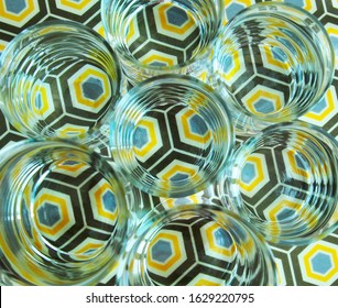 Top View Of Several Clear Glasses With Water Create Distorted Image Of Colourful Octagonal Pattern And Infinity Effect Of Circular Shapes. Visual Perception And Refraction. 