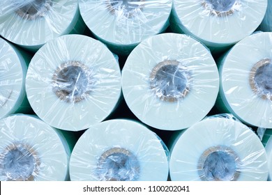 Top view of several round paper rolls packed in plastic at modern factory, production and recycling concept, copy space