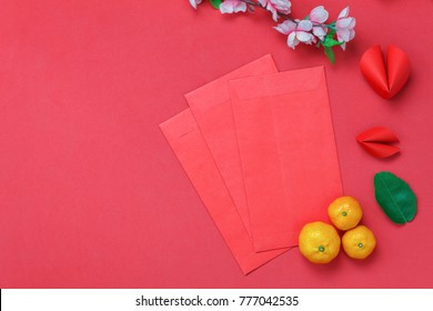 Top view shot of arrangement decoration Chinese new year & lunar festival background concept.Orange & red packet money also DIY paper crafts fortune cookies.object on modern red wooden at home desk.