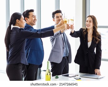 Top view shot Asian happy cheerful professional successful businessman and businesswoman in formal business suit standing smiling holding tall champagne glass toasting celebrating cheers together.