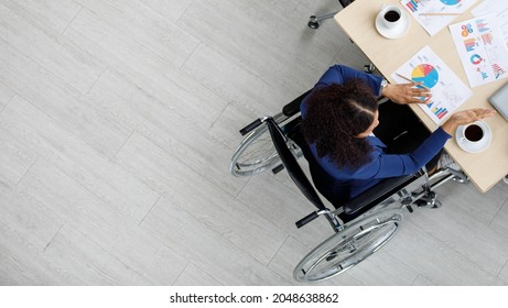 Top view shot of Asian unidentified unrecognizable female handicapped disabled businesswoman officer staff in formal business clothing sitting on wheelchair working meeting with other workers on desk. - Powered by Shutterstock