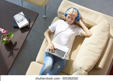 Top View Shot Of A Beautiful Woman Relaxing And Listening Music While Lying On Her Cozy Sofa At Home. 