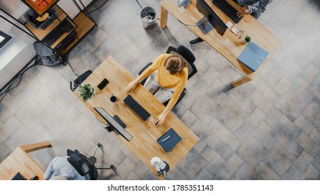 Top View Shot Of A Beautiful Young Female Specialist Sitting At Her Desk Working On Desktop Computer. Diverse And Modern Office With Professionals Doing Their Jobs.