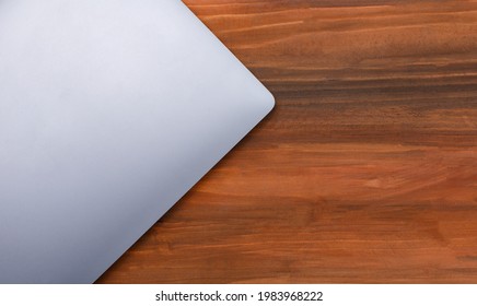 Top View Shot Closed Gray Laptop Notebook Computer On Wood Background With Copy Space.