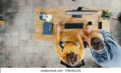 Top View Shot: Female Office Worker Uses Desktop Computer, Project Manager Stands Beside And Gives Advice On Optimizing Workflow For Customer Experience Management.