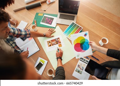 Top view shot of group of creative designers discuss the color palette during meeting. Creative team brainstorming around table. - Shutterstock ID 665740429