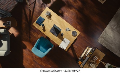 Top View Shot of Home Office: Stylish Empty Home Office Space, Wooden Desk, Laptop Computer, Wooden Floores, Very Tastefully Done. Contemporary Cozy Apartment with No Peope.