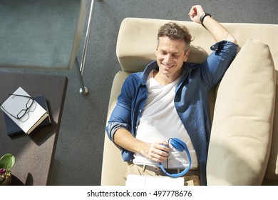 Top View Shot Of Man With Closed Eyes Lying On Cosy Sofa At Home And Relaxing.