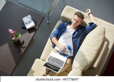 Top View Shot Of Man With Closed Eyes Lying On Cosy Sofa At Home And Relaxing.