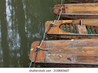 A top view shot of many Punts moored up at the Head of the River with green water on a sunny day