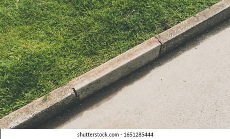 A Top View Shot Of The Pavement Curb Next To A Grass