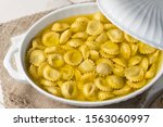 top view shot of steaming Anolini, a typical filled pasta of Piacenza, north italy, its served in hot beef broth inside a vintage white bowl