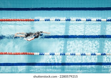 Top view shot of young man swimming laps in swimming pool. Male swimmer swimming the front crawl in a pool. swimming crawl. - Powered by Shutterstock