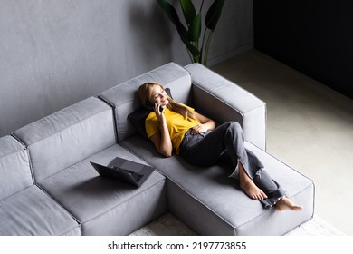 Top View Shot Of A Young Woman Talking With Somebody On Her Handy While In Sofa At Home.