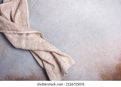 Top view of single folded linen serviette on grey concrete background with copy space