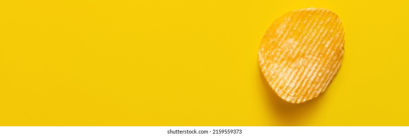 Top View Of Single Wavy And Salty Potato Chip On Yellow, Banner