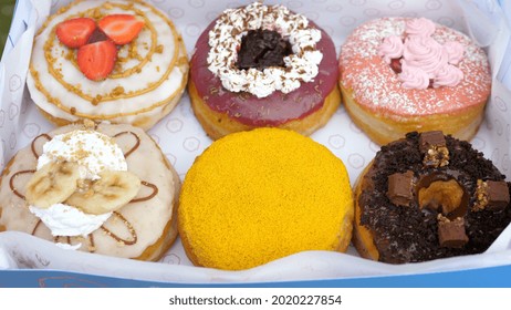 Top View Of Six Colourful Vegan Doughnuts In A Box