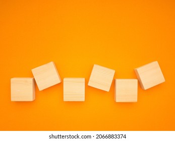 Top view of six empty wooden cubes isolated on a yellow background. Space for text.