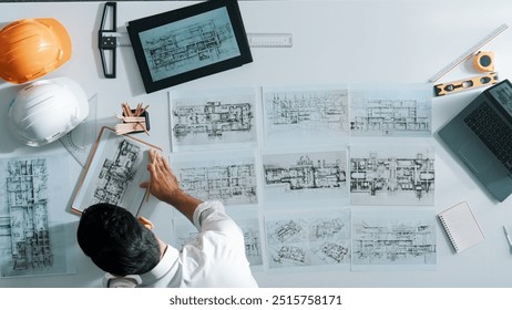 Top view of skilled civil engineer sitting and writing idea while looking at house model. Aerial view of architect or designer planning and thinking about creative building construction. Alimentation. - Powered by Shutterstock