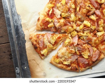 Top View Sliced Homemade Pineapple And Sausage Pizza On Baking Tray