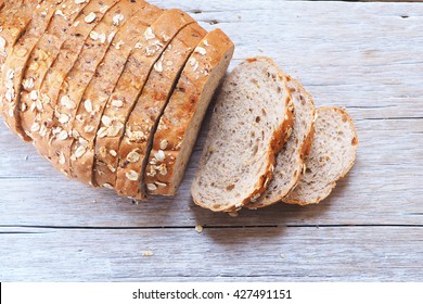 Top view of sliced wholegrain bread on a wooden table.