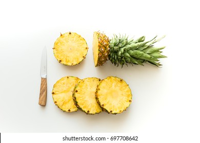 Top View Of Slices Of Fresh Pineapple With Knife Isolated On White