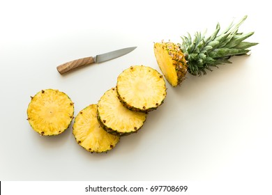 Top View Of Slices Of Fresh Pineapple With Knife Isolated On White