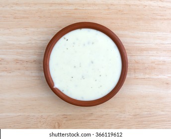 Top View Of A Small Bowl Of Ranch Dressing On A Wood Table Top Illuminated With Natural Light.