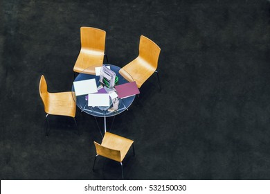 Top View Of A Small Business Meeting Round Table With Four Chairs On Black Floor Copy Space