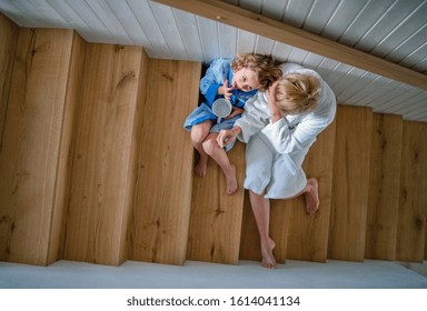 Top View Of Small Girl With Mother Indoors At Home, Sitting On Stairs In The Morning.