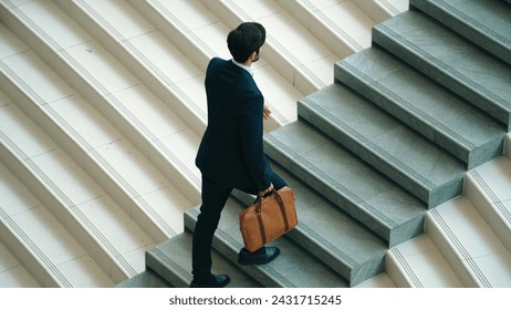 Top view of smart business man walking up stairs with bag in the hand. Professional project manager climb up the stair and going to workplace. Increasing skill, getting promotion, traveling. Exultant. - Powered by Shutterstock