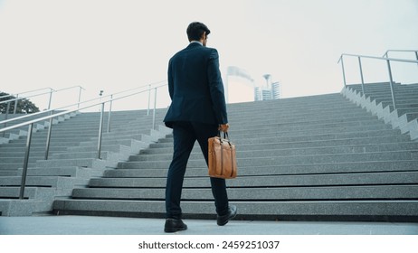 Top view of smart business man walking up stairs with bag in the hand. Professional project manager climb up the stair and going to workplace. Increasing skill, getting promotion, traveling. Exultant. - Powered by Shutterstock