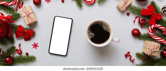 top view of smart phone with hot cup of coffee. Christmas decoration on colored background. - Powered by Shutterstock