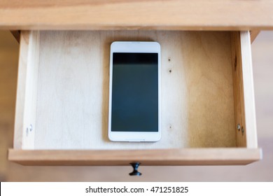 top view of smartphone in open drawer of nightstand - Shutterstock ID 471251825