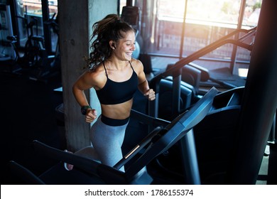 Top View Of Smiling Woman Exercising And Training In The Gym On Treadmill Running Machine. Healthy Lifestyle And Positive People.