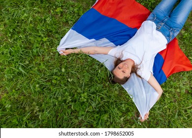 Top view smiling woman lies on national Russia flag outdoors green grass at summer - russian flag, country, patriotism, Russia day and 12th june