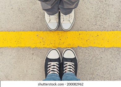 Top View Of Sneakers From Above, Male And Female Feet In Sneakers, Standing At Dividing Frontier Line.