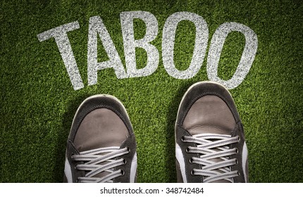 Top View Of Sneakers On The Grass With The Text: Taboo