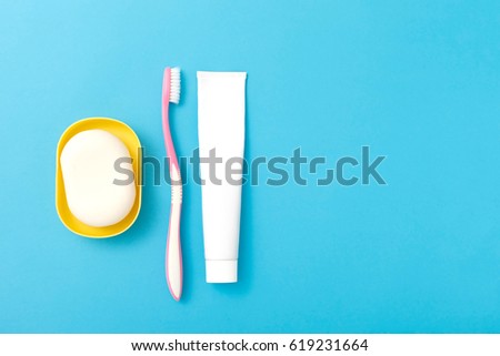 Top view of soap, toothbrush and toothpaste. Personal hygiene kit. Isolated on blue background. Free space for text