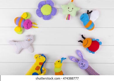 Top View With Soft Baby Toys On Wooden Background