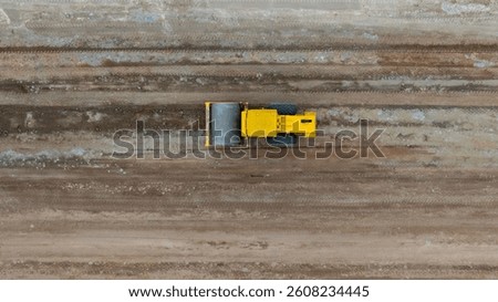 Top view soil compactor road roller leveling ground for foundation road construction, Soil compactor compresses soil construction site, Road roller soil compactor working new road construction site.