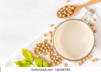 Top View Of Soy Or Soya Milk In A Glass With Soybeans In A Wooden Bowl Background