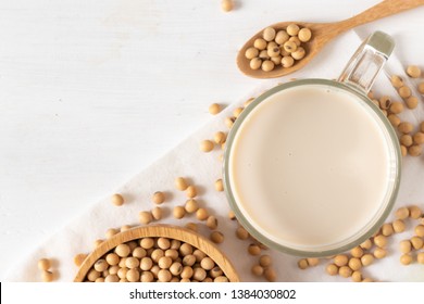 Top View Of Soy Or Soya Milk In A Glass With Soybeans In A Wooden Bowl Background