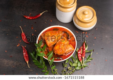 Top view of spicy and hot king fish curry with green curry leaf Kerala India. Barracuda Fish curry with red chili powder, coconut milk Asian cuisine.