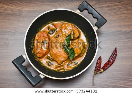 Top view of spicy and hot king fish curry with green curry leaf Kerala India/Indian food. Barracuda Fish curry with red chili, curry leaf, coconut milk and mango Asian cuisine..